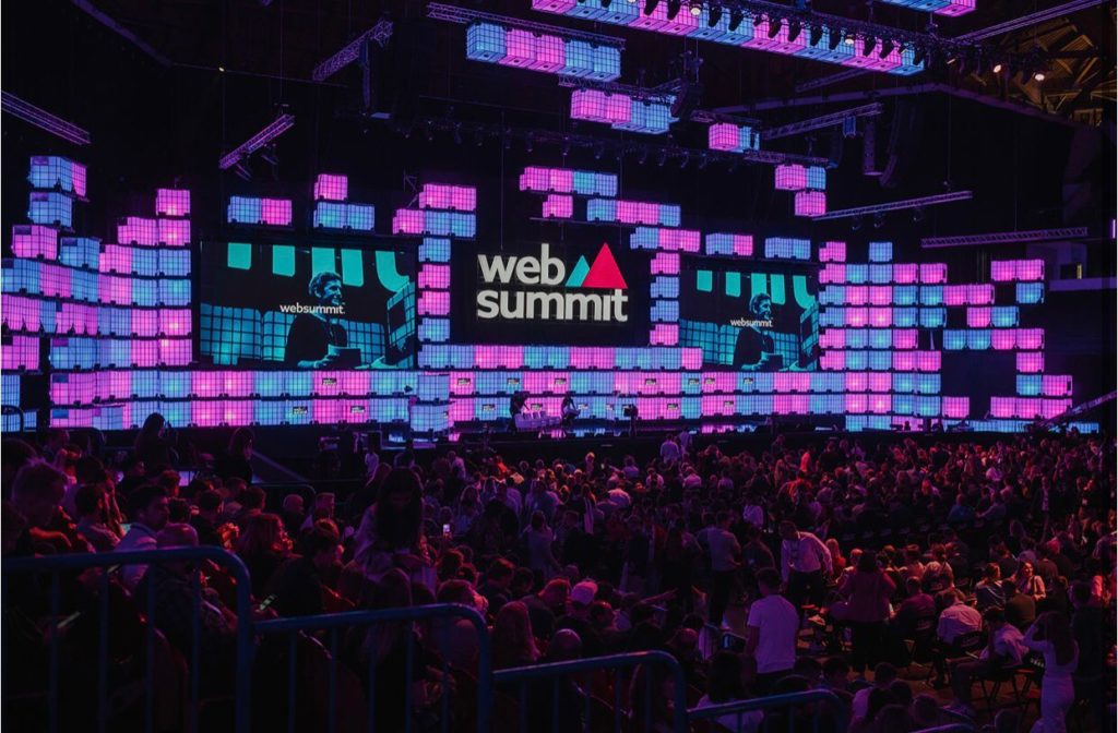 Painéis em azul e rosa com um ao meio em preto escrito "WebSummit" em fonte branca