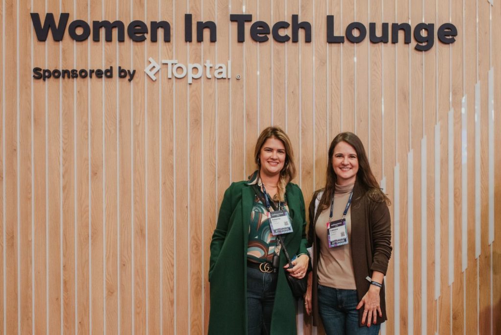 Equipe HUNTINGTI posando em frente a parede com textura de madeira no evento "Women In Tech Lounge"
